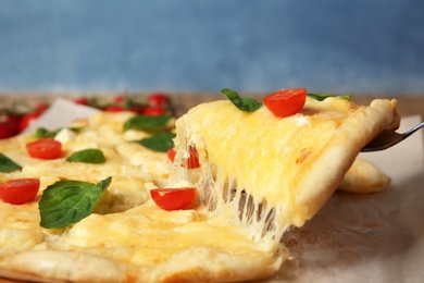 Taking tasty homemade pizza slice with melted cheese, closeup