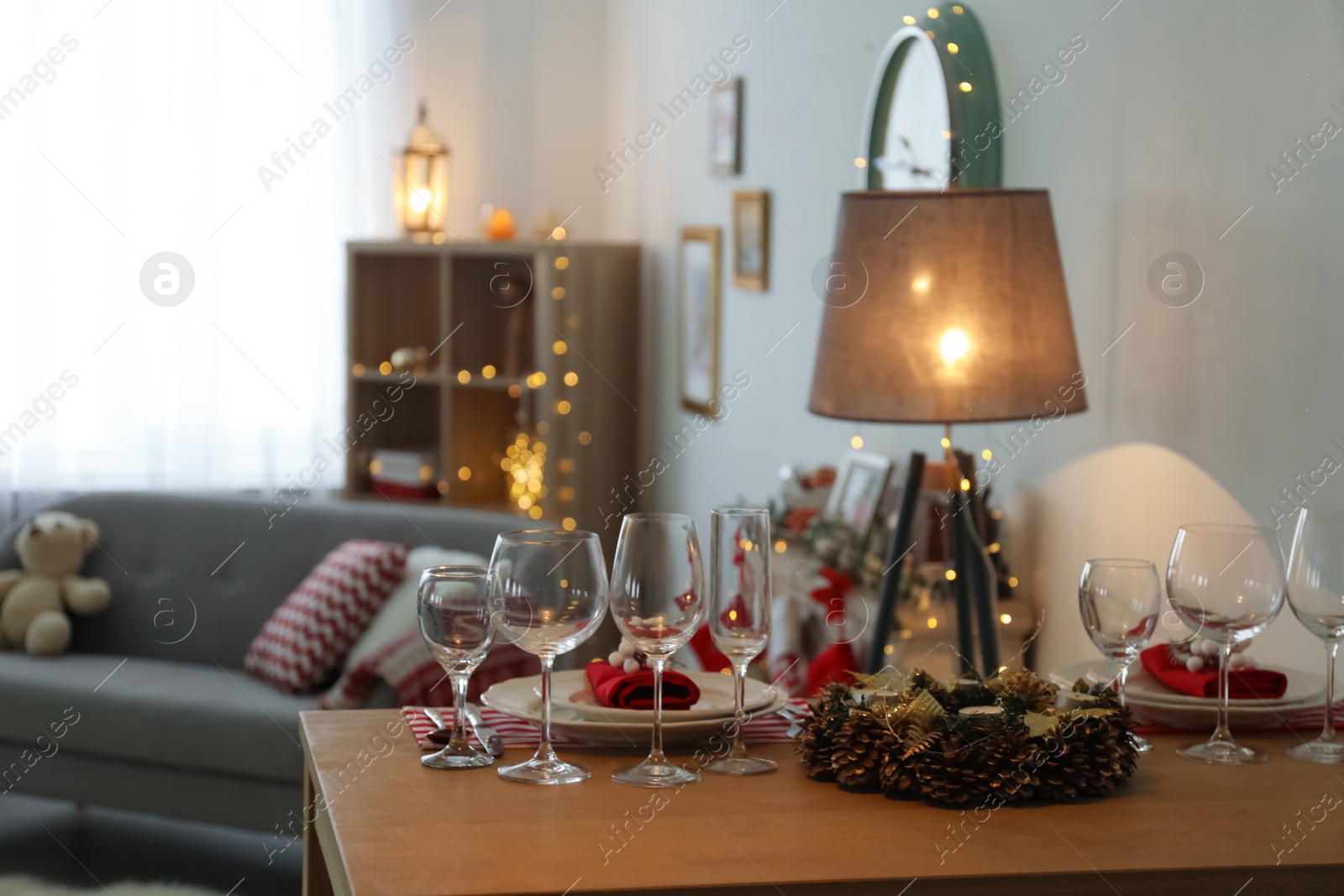 Photo of Set of dinnerware and Christmas wreath on table indoors