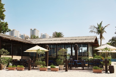 Restaurant with outdoor seating area at tropical resort on sunny day