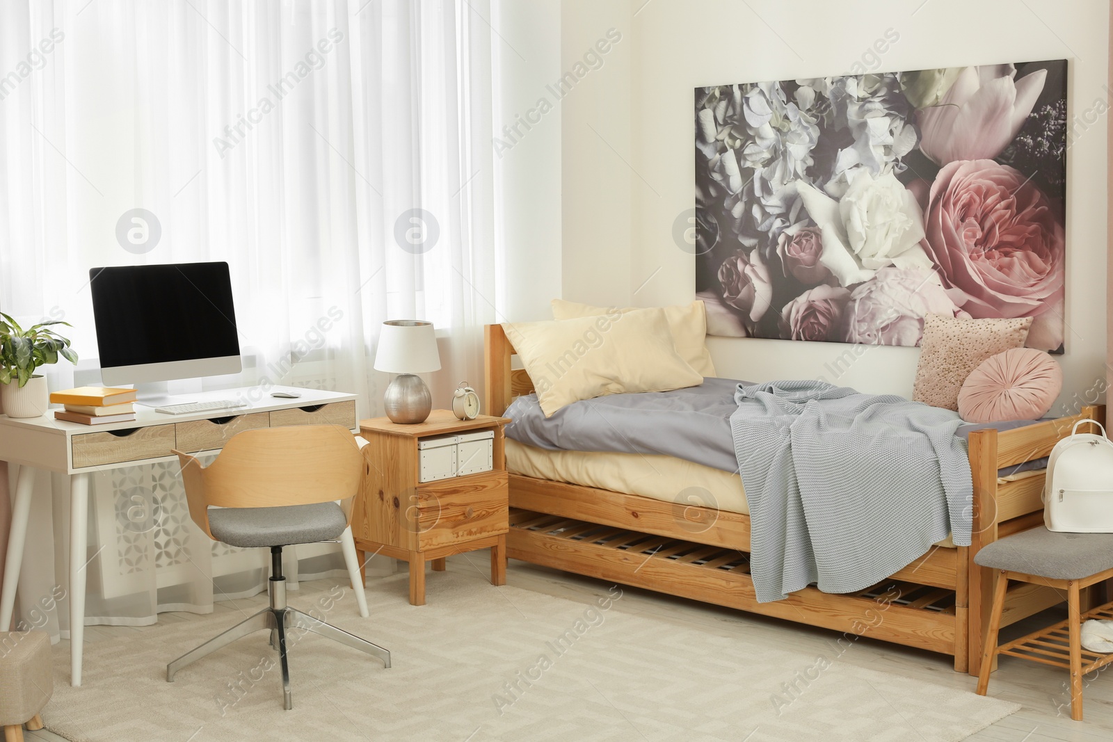 Photo of Stylish teenager's room interior with computer and comfortable bed