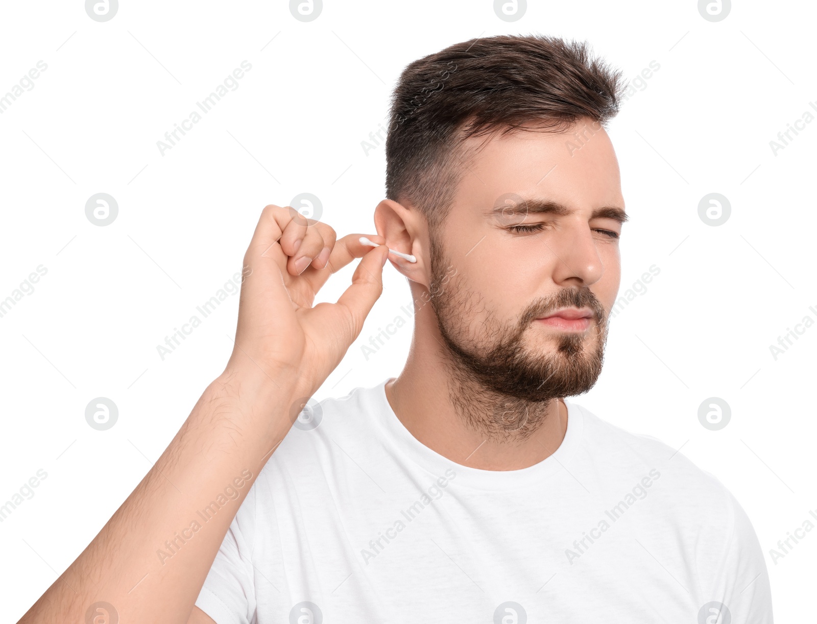 Photo of Young man cleaning ear with cotton swab on white background