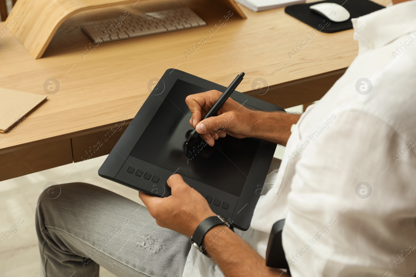 Photo of Professional retoucher working on graphic tablet at desk, closeup