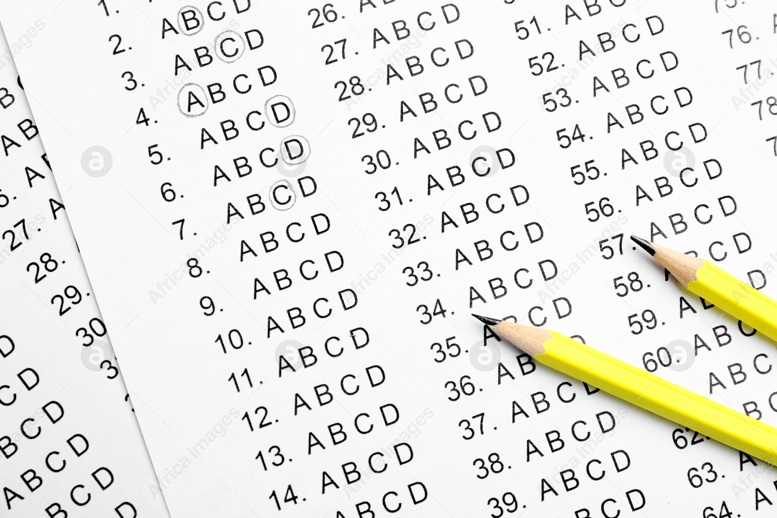 Photo of Yellow pencils on answer sheets, top view