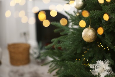 Photo of Christmas balls hanging on fir tree indoors, closeup. Space for text