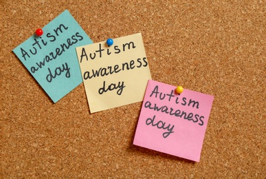 Photo of Notes with phrase "Autism awareness day" on cork background
