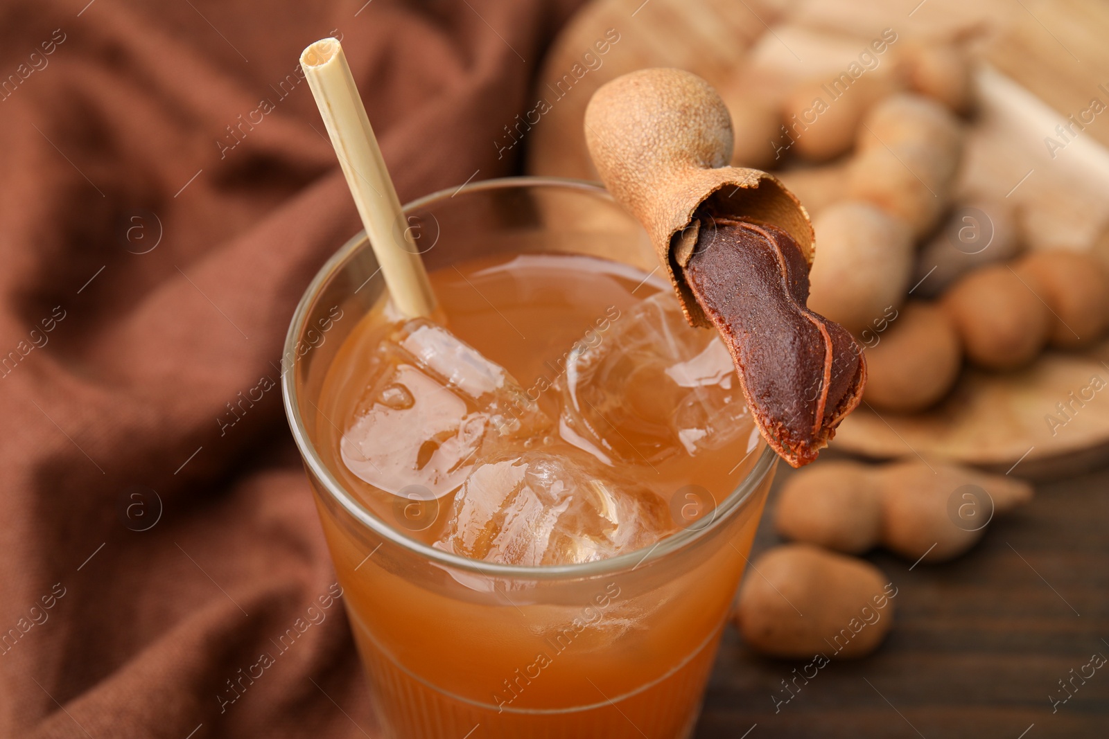 Photo of Freshly made tamarind juice and fresh fruit on table, closeup