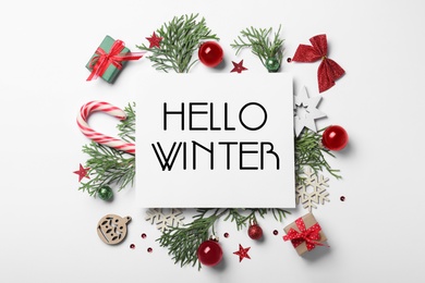 Image of Greeting card with text Hello Winter, gift boxes and Christmas decor on white background, flat lay