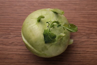 Photo of Whole ripe kohlrabi plant on wooden table, top view