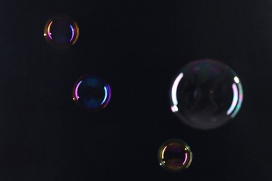 Photo of Beautiful transparent soap bubbles on dark background