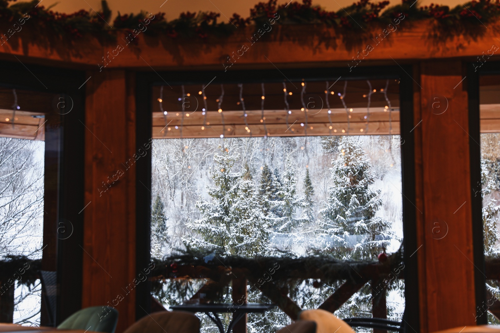 Photo of View on picturesque snowy forest from cafe window. Winter vacation