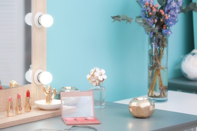 Photo of Decorative cosmetics and tools on dressing table near mirror in makeup room