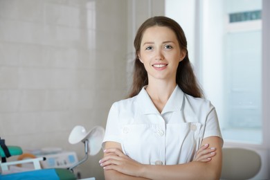 Photo of Portrait of smiling young gynecologist at workplace in clinic
