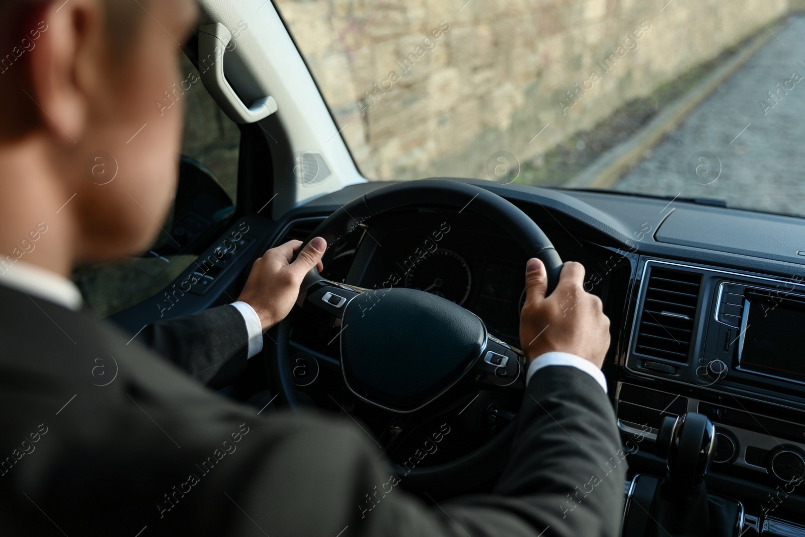 Photo of Professional driver in luxury car, closeup. Chauffeur service