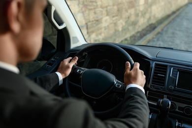 Photo of Professional driver in luxury car, closeup. Chauffeur service