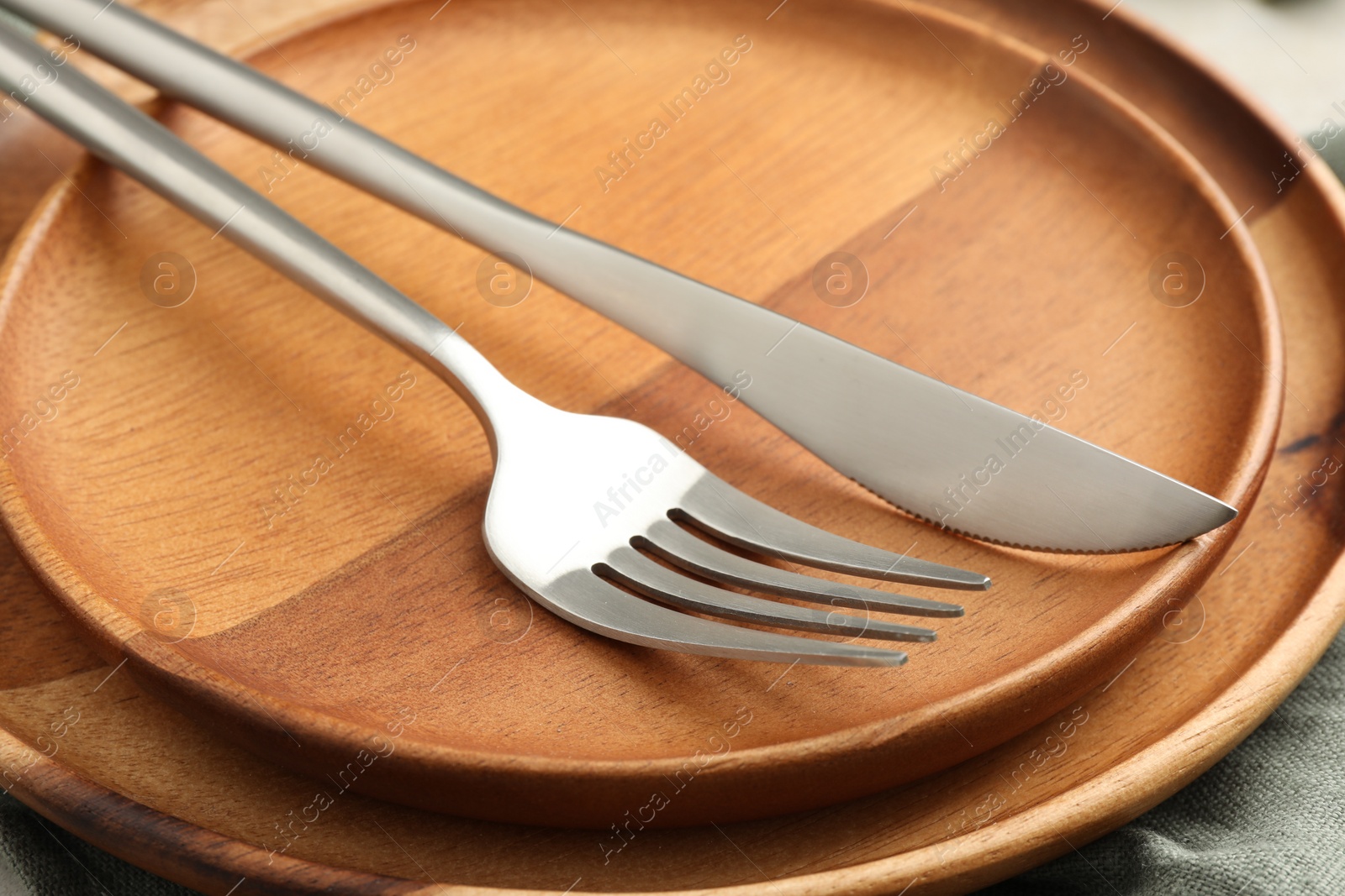 Photo of Stylish setting with cutlery, napkin and plates on table, closeup