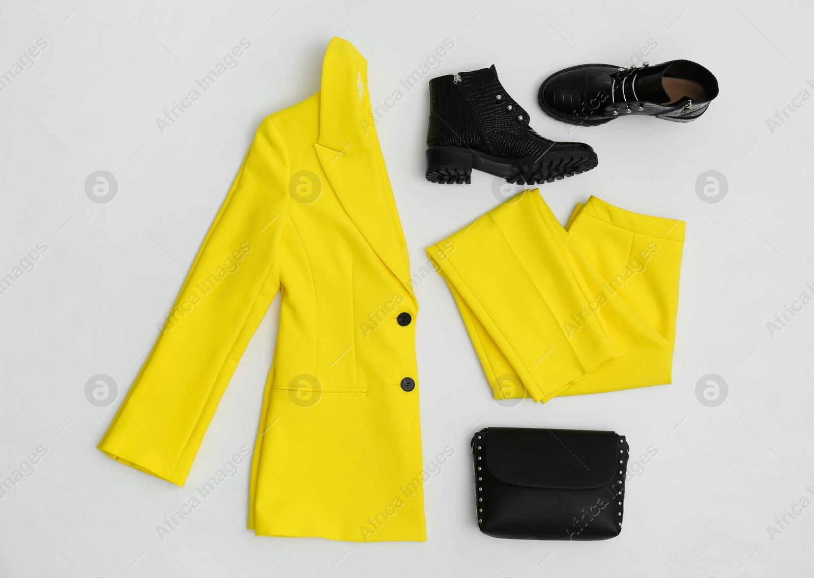 Photo of Stylish ankle boots, handbag and yellow office suit on white background, top view
