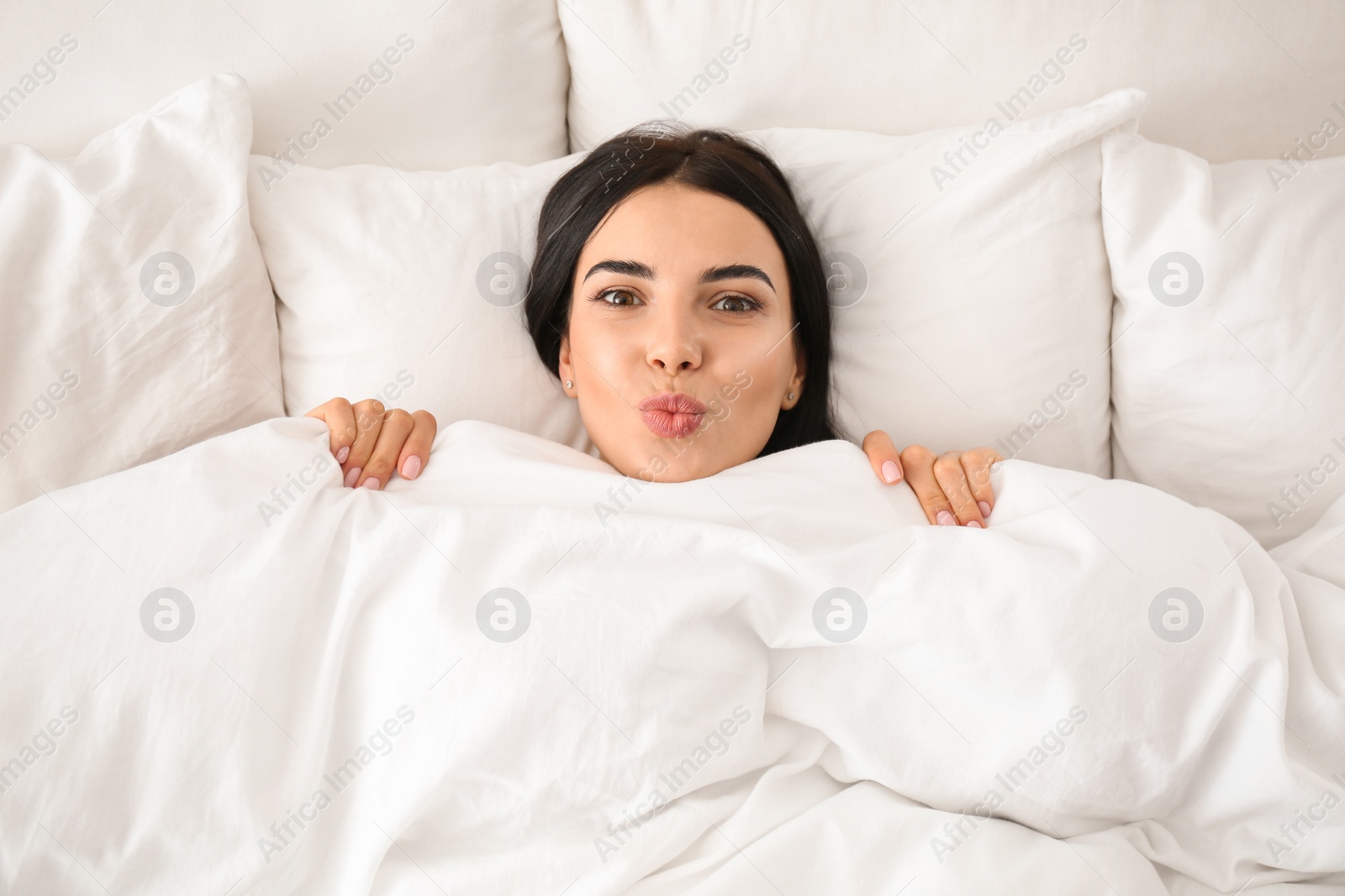 Photo of Young woman awakening at home, top view. Lazy morning