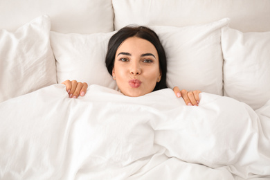 Photo of Young woman awakening at home, top view. Lazy morning