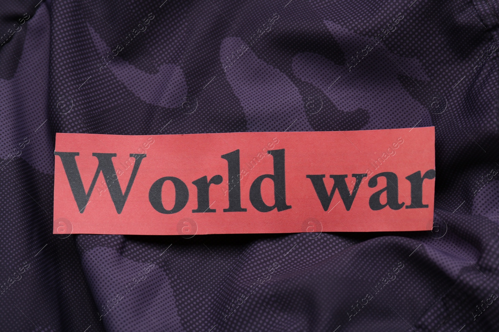 Photo of Card with words World War on color fabric, top view