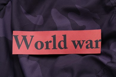 Photo of Card with words World War on color fabric, top view