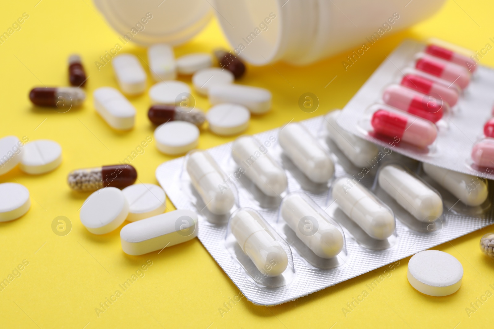 Photo of Different antidepressants on yellow background, closeup view