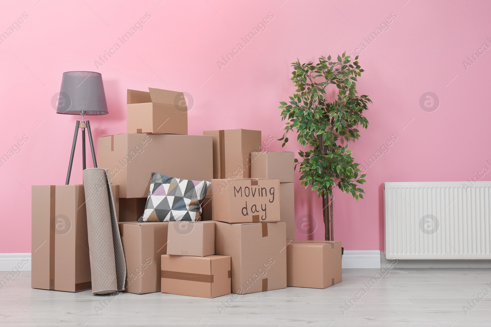 Photo of Cardboard boxes and household stuff in empty room. Moving day