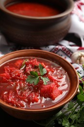 Stylish brown clay bowl with Ukrainian borsch served on table
