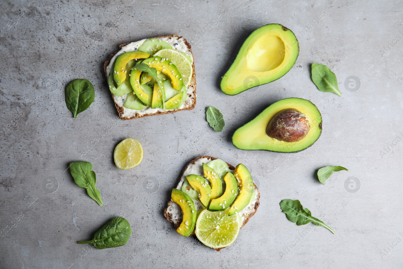 Photo of Flat lay composition with avocado toasts on grey table