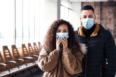 Couple with disposable masks indoors. Virus protection