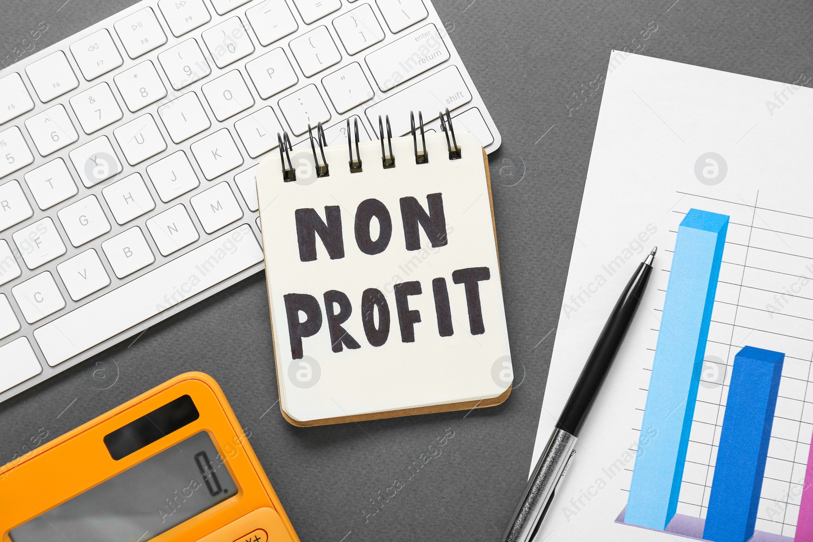 Photo of Non Profit concept. Flat lay composition with notebook and keyboard on grey table