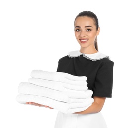 Photo of Young chambermaid with stack of clean towels on white background