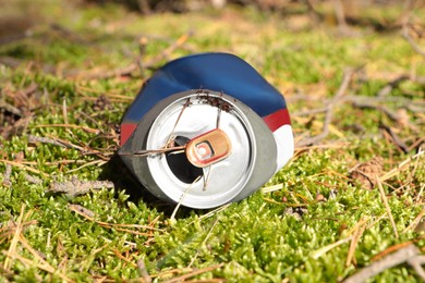 Photo of Used aluminum can on grass outdoors. Recycling problem