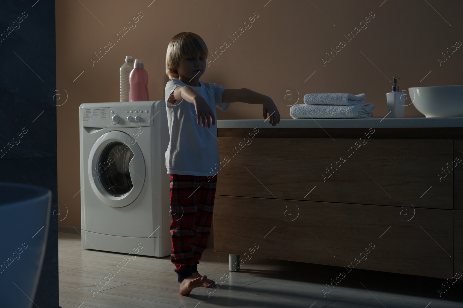 Photo of Boy in pajamas sleepwalking indoors at night