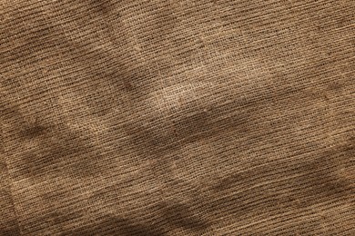 Photo of Texture of natural burlap fabric as background, top view