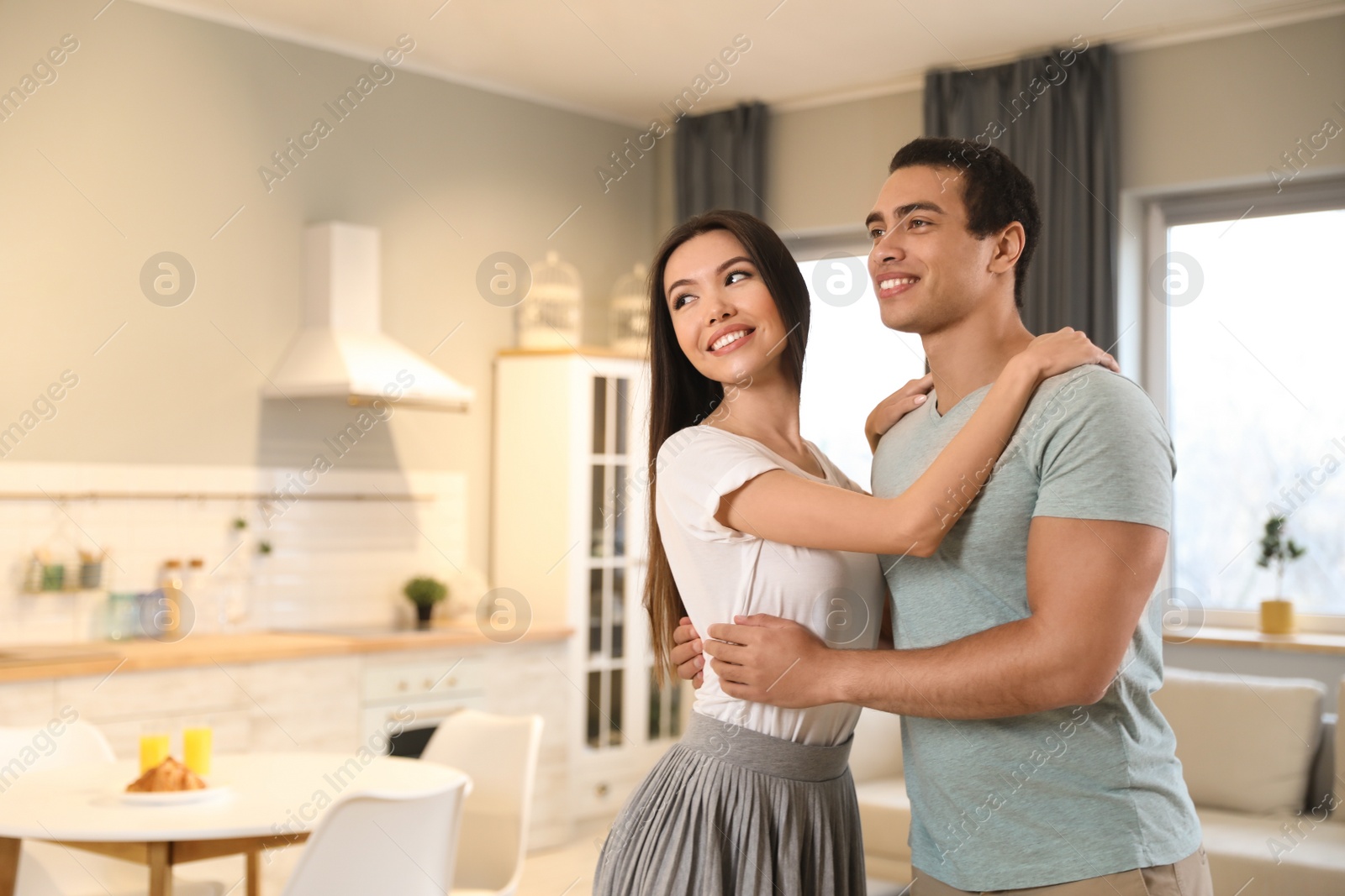 Photo of Lovely young interracial couple dancing at home. Space for text