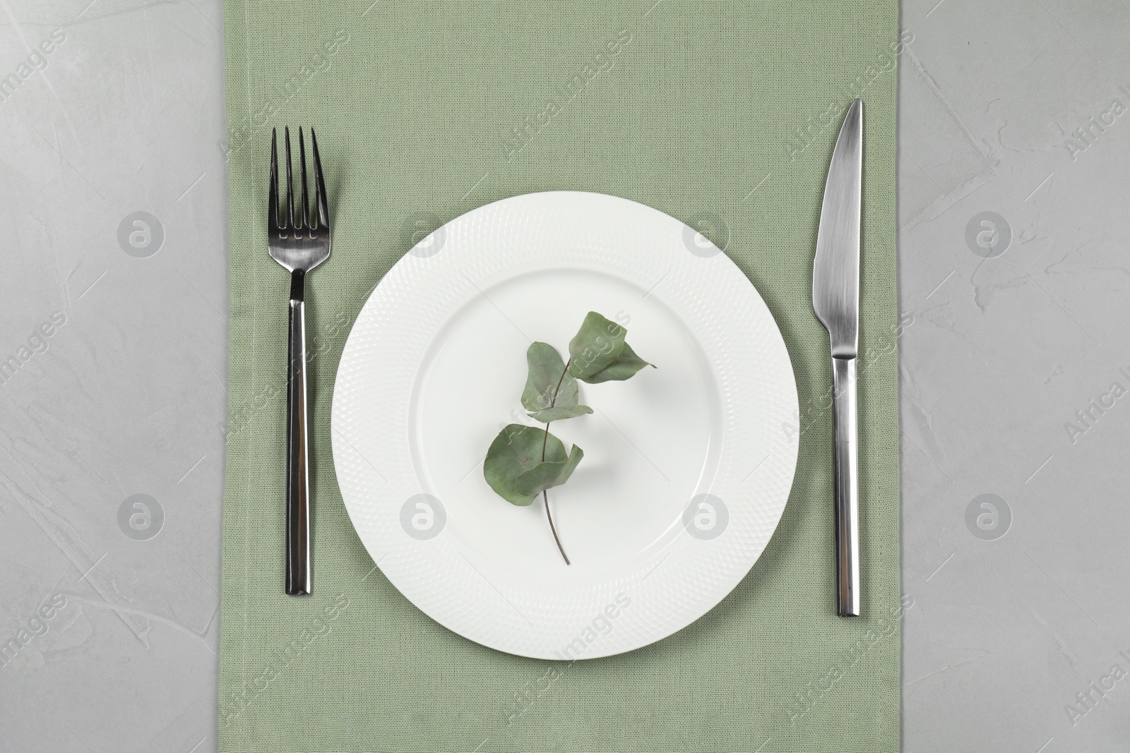 Photo of Stylish setting with elegant cutlery on grey table, top view