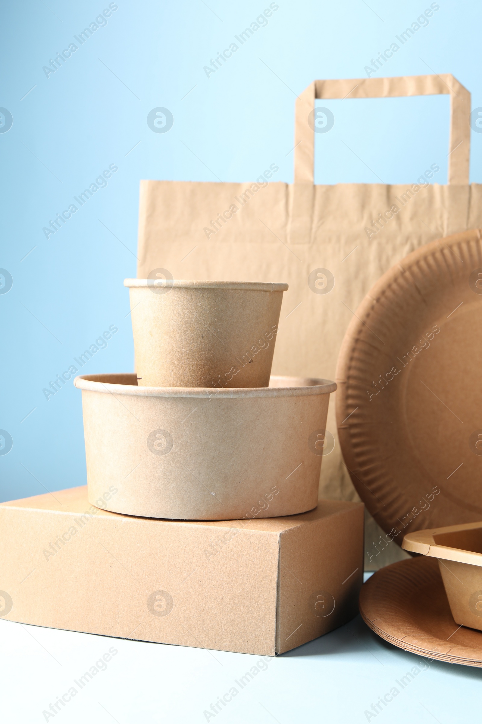 Photo of Eco friendly food packagings on white table against light blue background