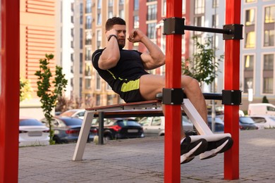 Man doing abs exercise on bench at outdoor gym