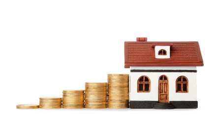 House model and coins on white background. Heating price concept