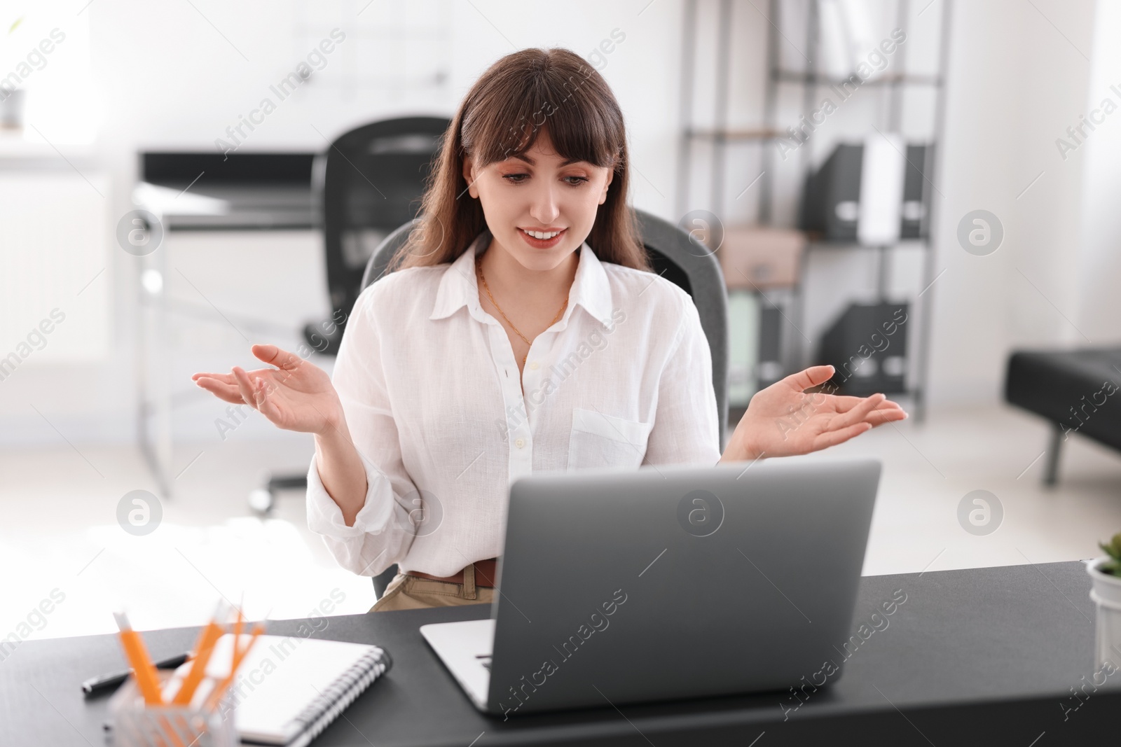 Photo of Woman watching webinar at table in office