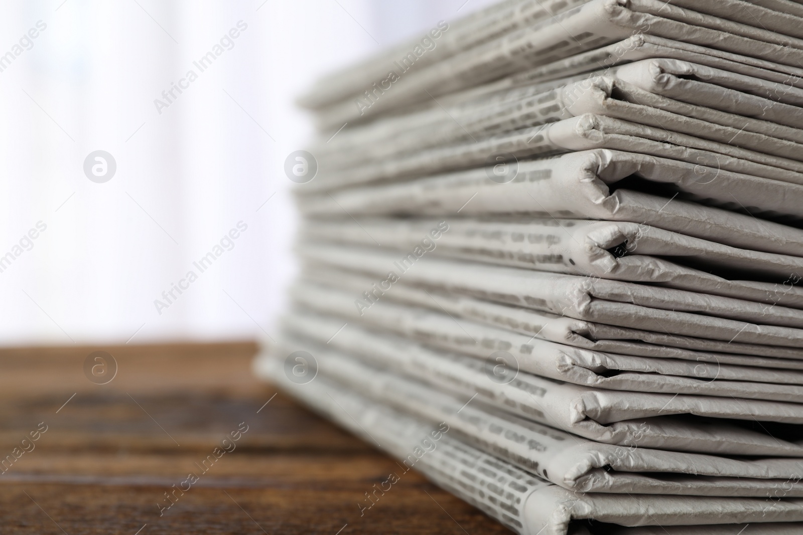 Photo of Stack of newspapers on wooden table, space for text. Journalist's work