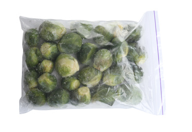 Photo of Frozen Brussels sprouts in plastic bag isolated on white, top view. Vegetable preservation