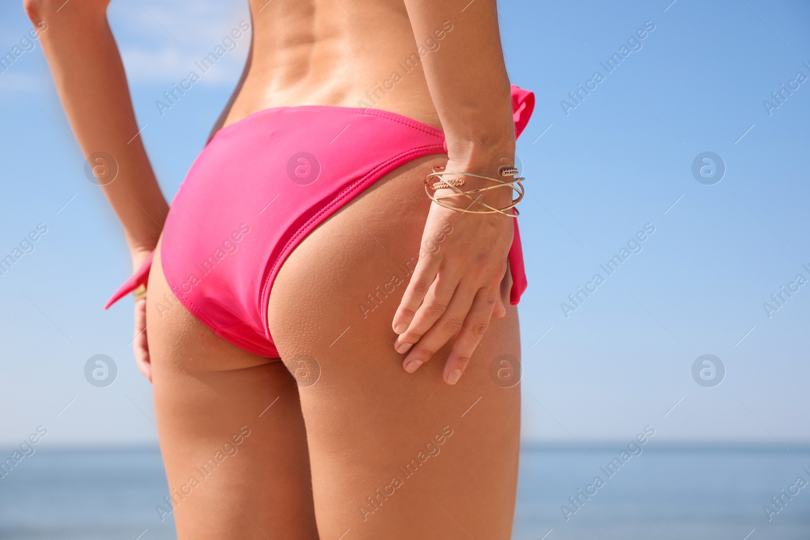 Photo of Young woman with beautiful body on beach, closeup