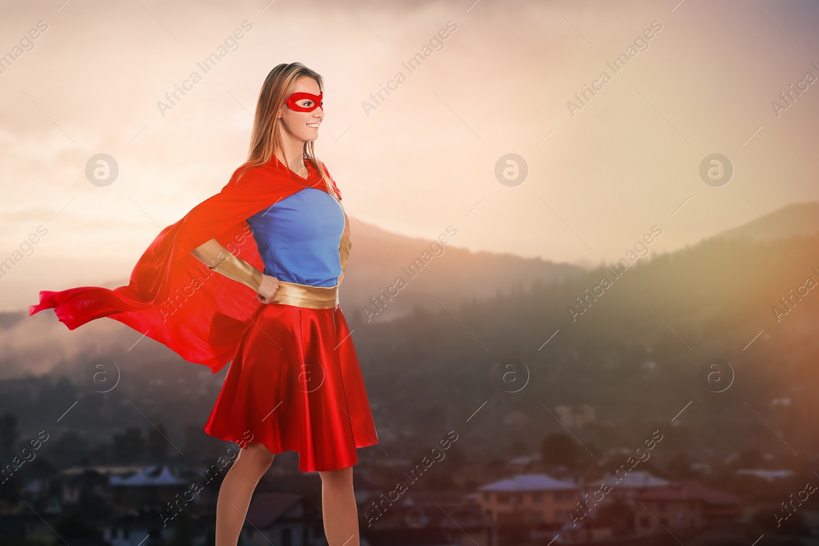 Image of Superhero, motivation and power. Woman in cape and mask on high top in mountains