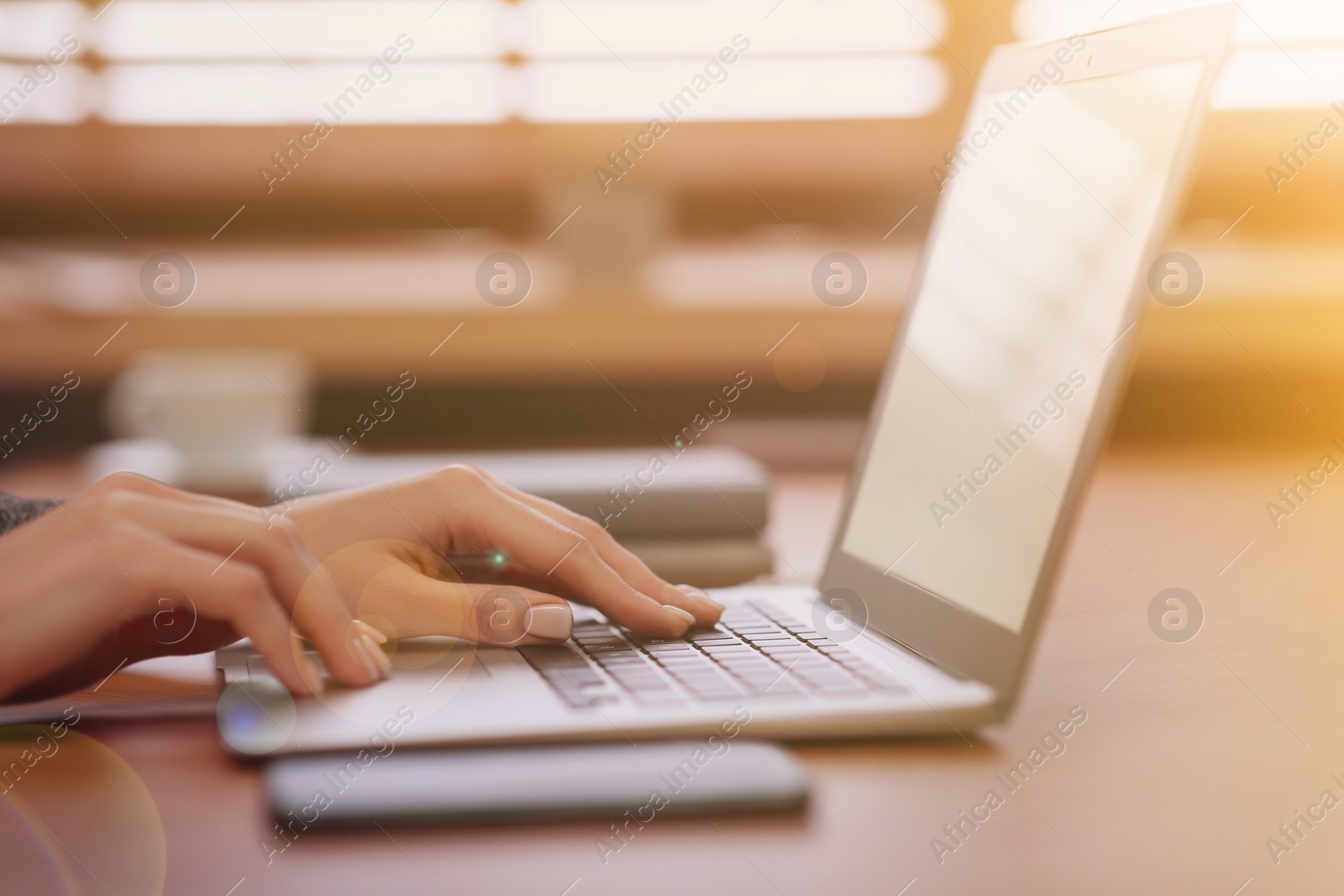 Image of Woman working with laptop at table indoors, closeup
