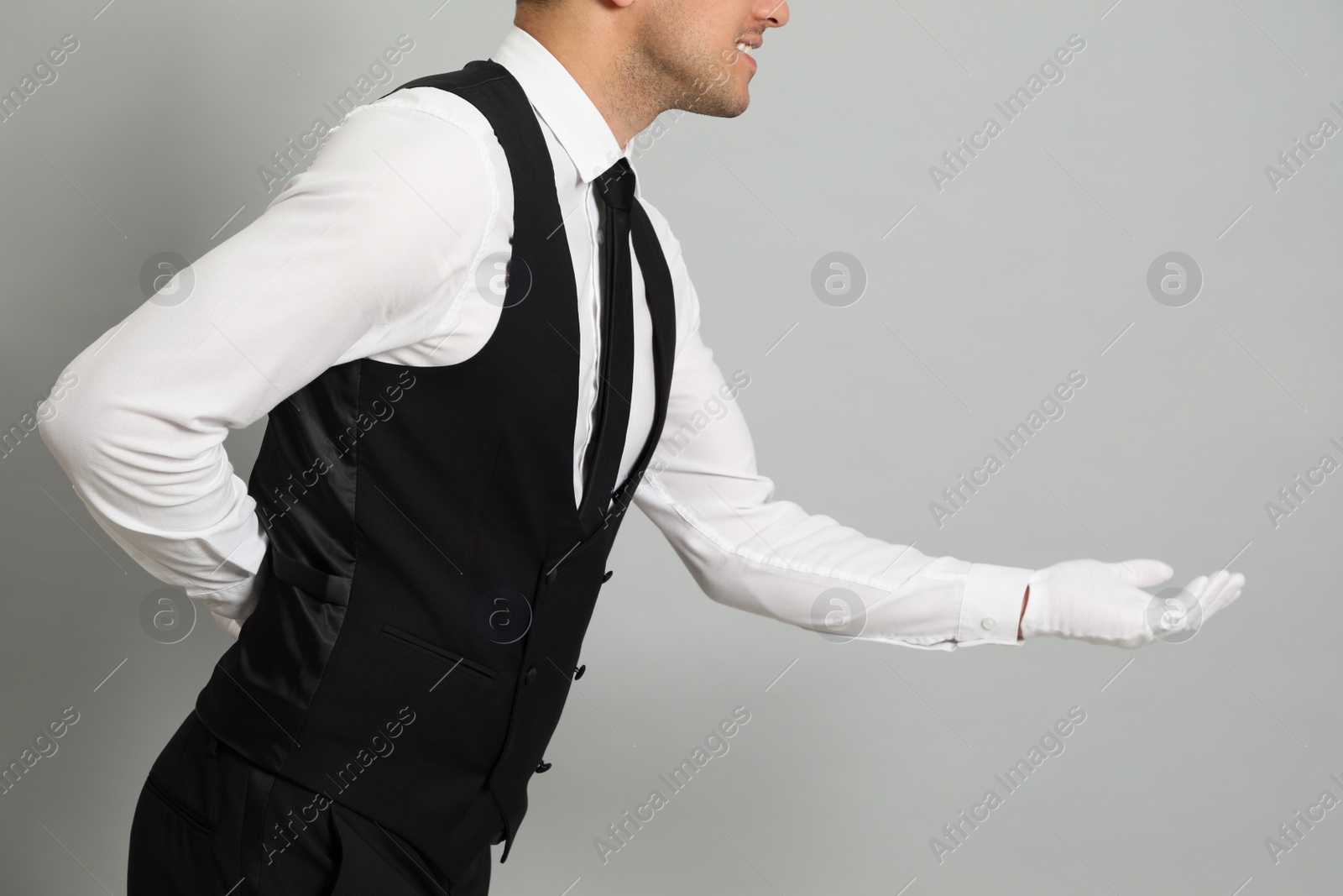 Photo of Butler in elegant uniform on grey background, closeup