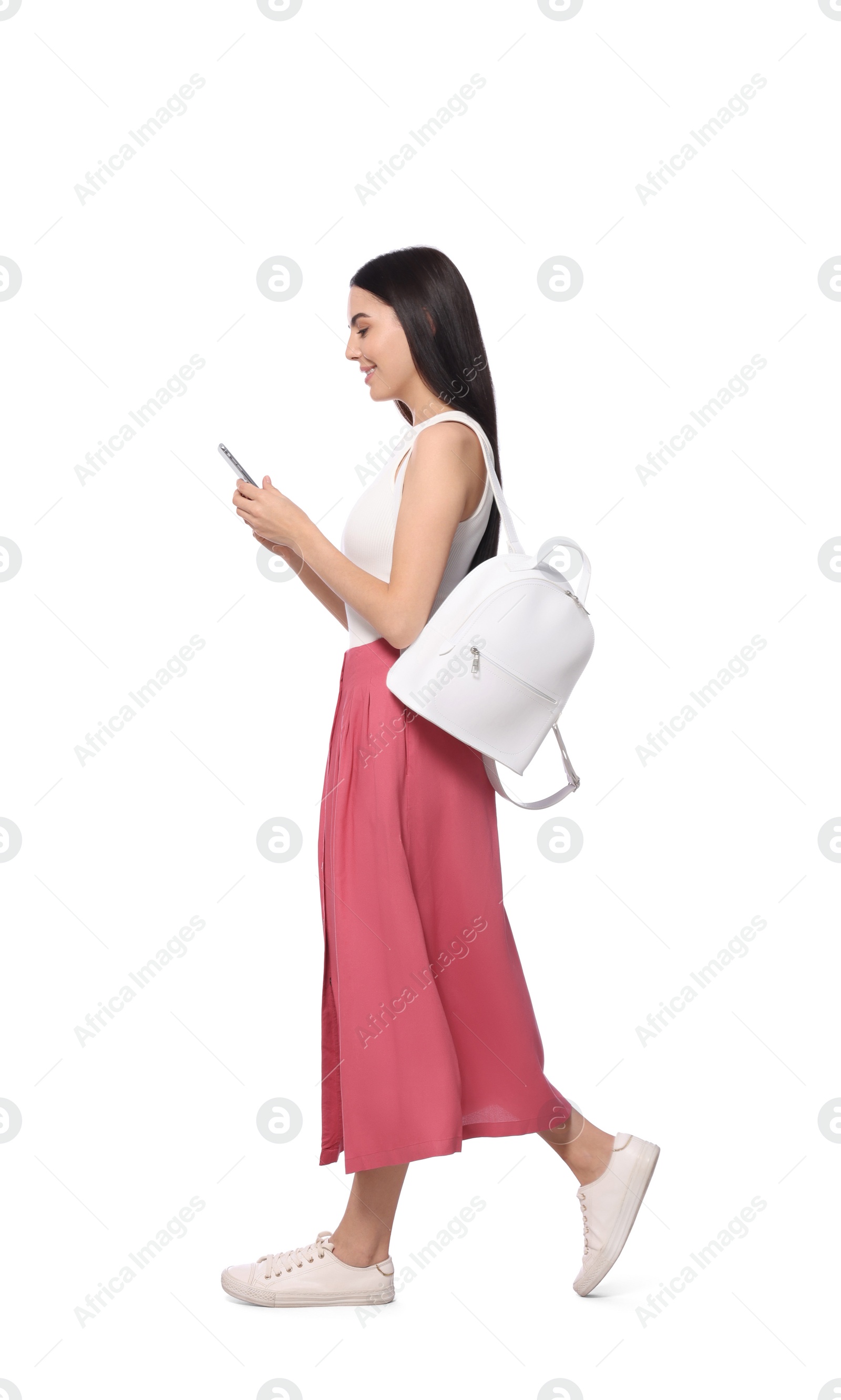 Photo of Young woman using smartphone while walking on white background