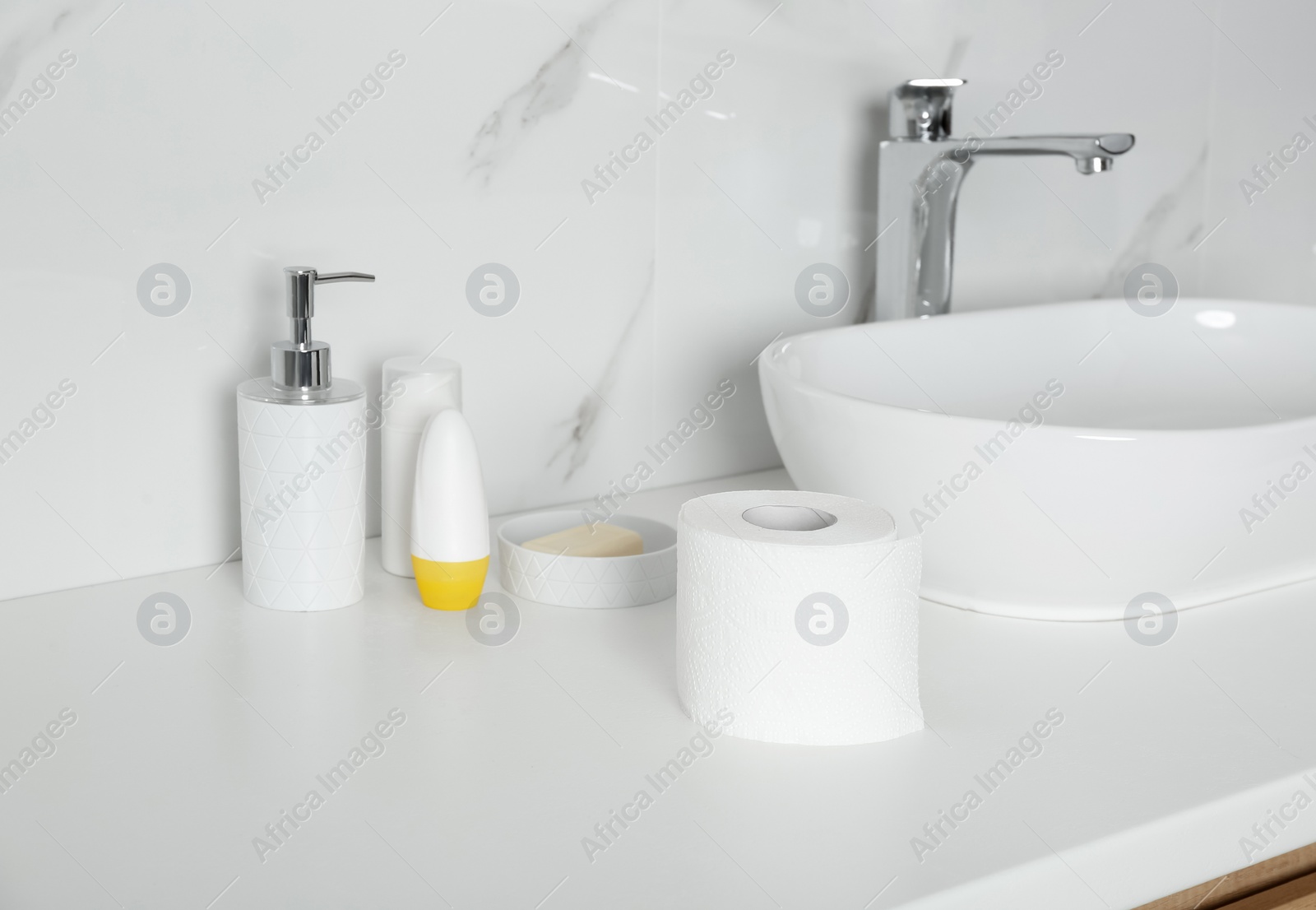 Photo of New toilet paper roll on countertop in bathroom