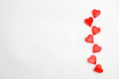 Photo of Sweet heart shaped jelly candies on white background, flat lay. Space for text