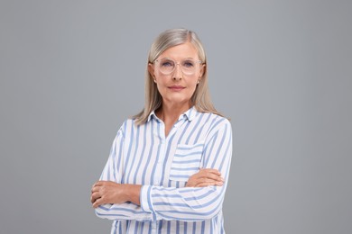 Photo of Portrait of beautiful middle aged woman in eyeglasses on light grey background